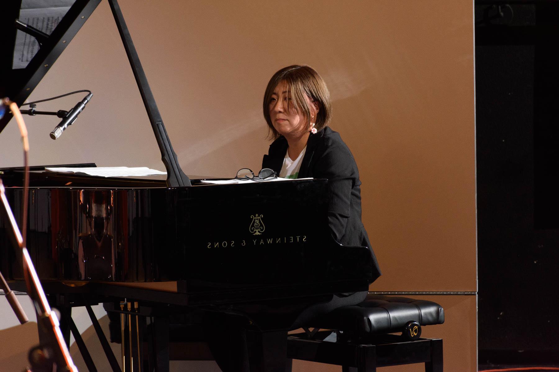 A female pianist is seen playing a Steinway grand piano.